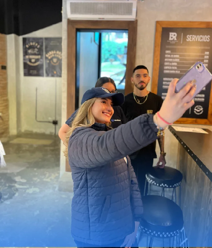 Barberos tomándose una selfie en su local, imagen testimonial sobre el uso de Weibook